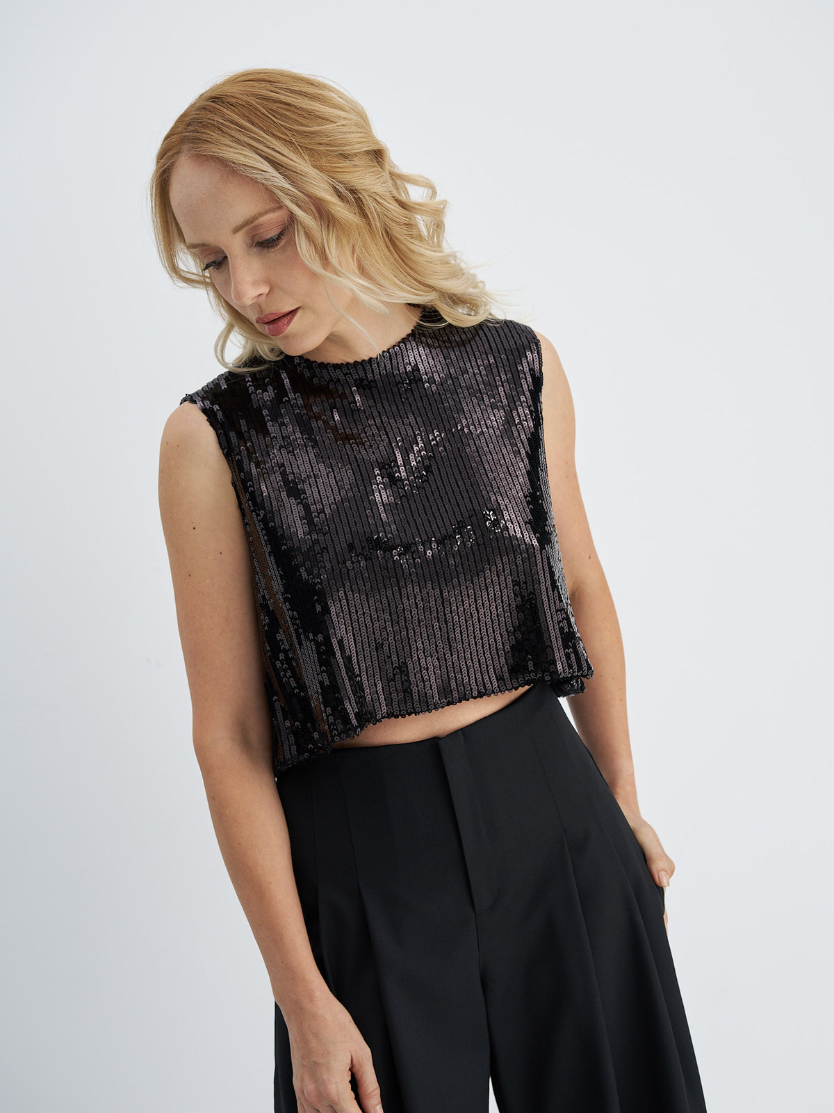 Front view of black sequin crop top showing its relaxed fit and cropped hem