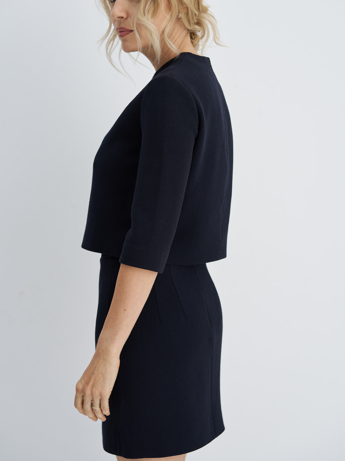 Side view of wool-crepe crop top showing its short silhouette and three-quarter sleeves