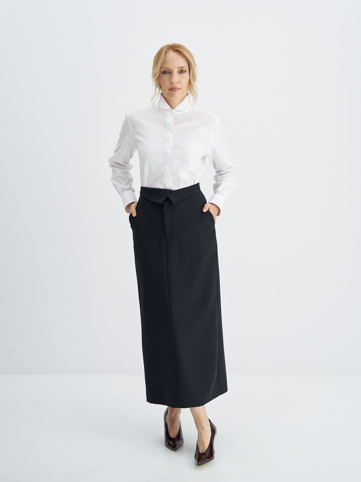High-waisted wool-mohair midi skirt styled with a white shirt and burgundy pumps
