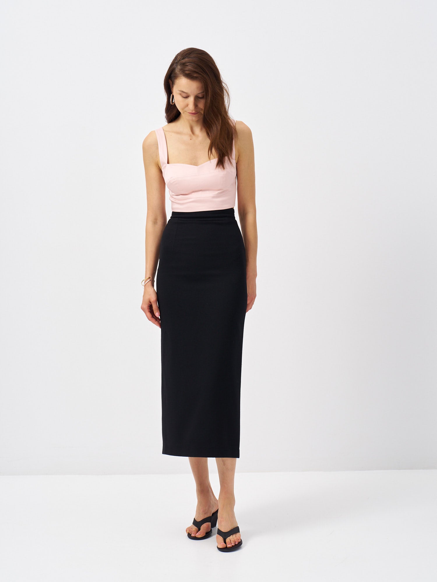 Black wool midi pencil skirt with a high-rise waist and streamlined silhouette