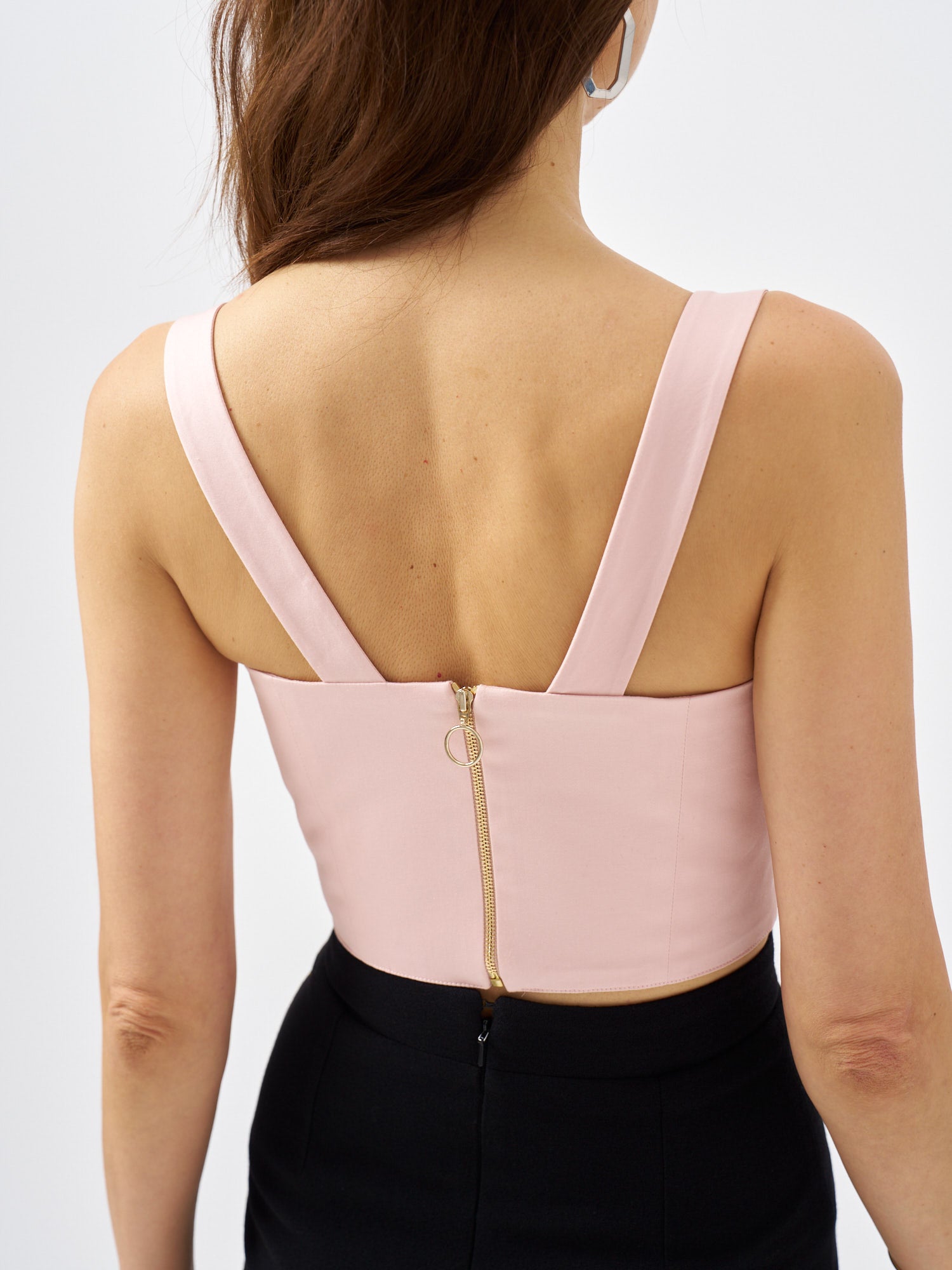 Back view of a pale pink cotton satin top with wide straps and exposed gold-tone metal zip fastening.