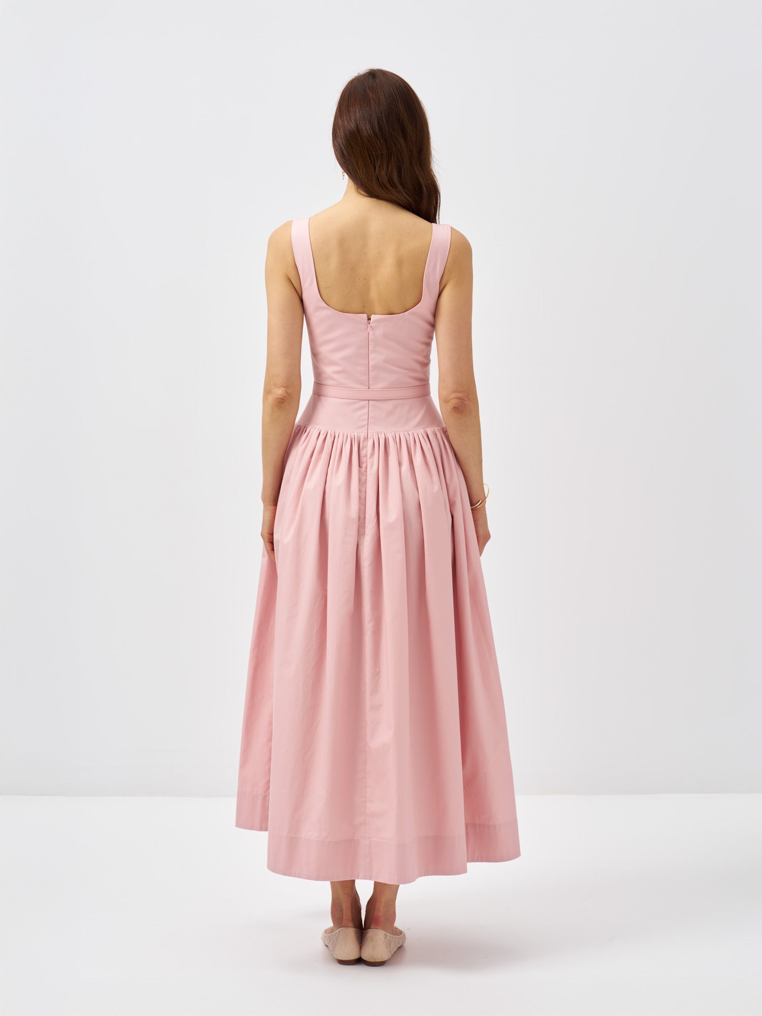Back view of a pink cotton poplin maxi dress with a gathered skirt and defined silhouette