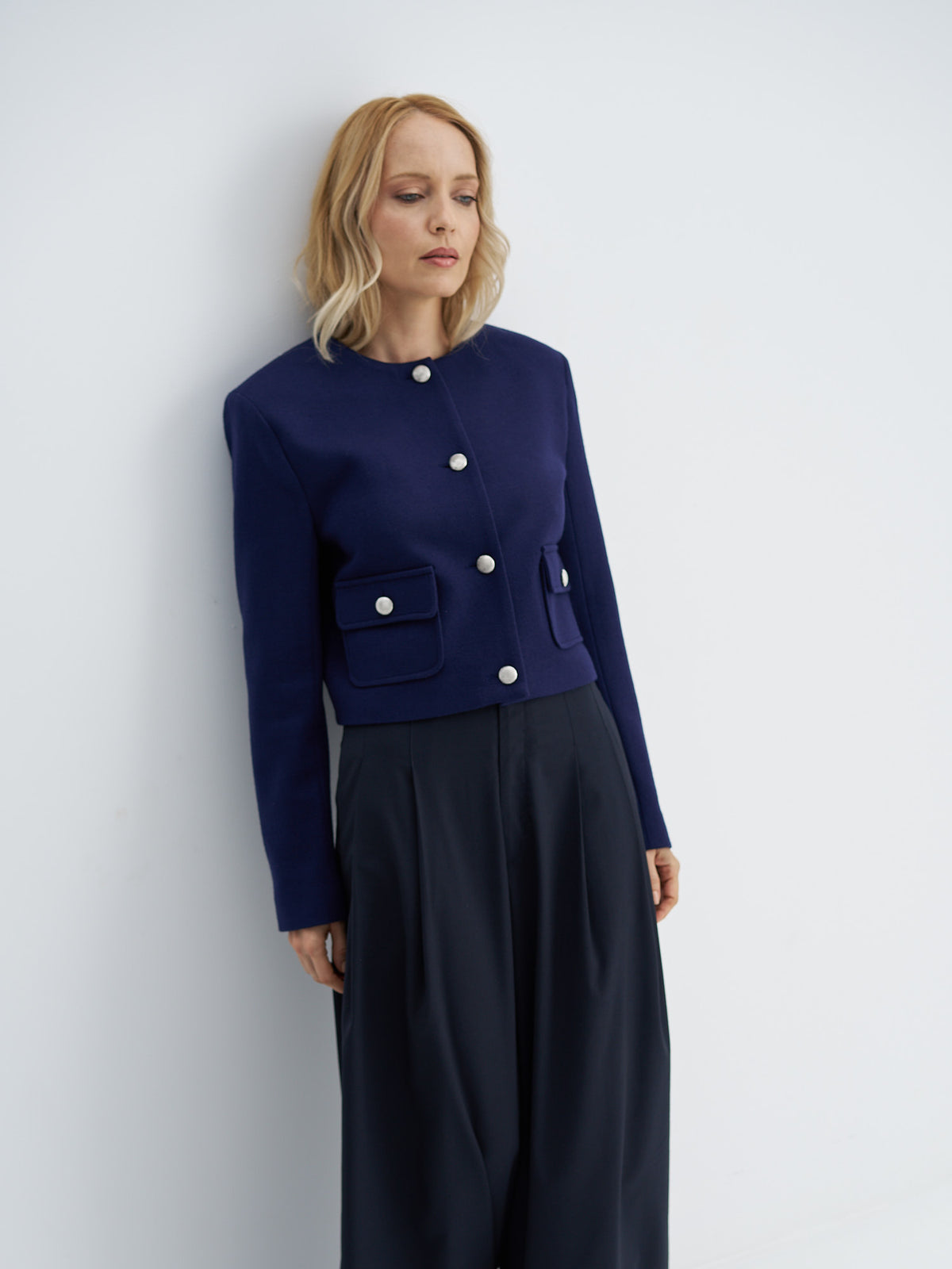 Indigo navy cropped wool jacket worn buttoned with high-waisted wide-leg trousers