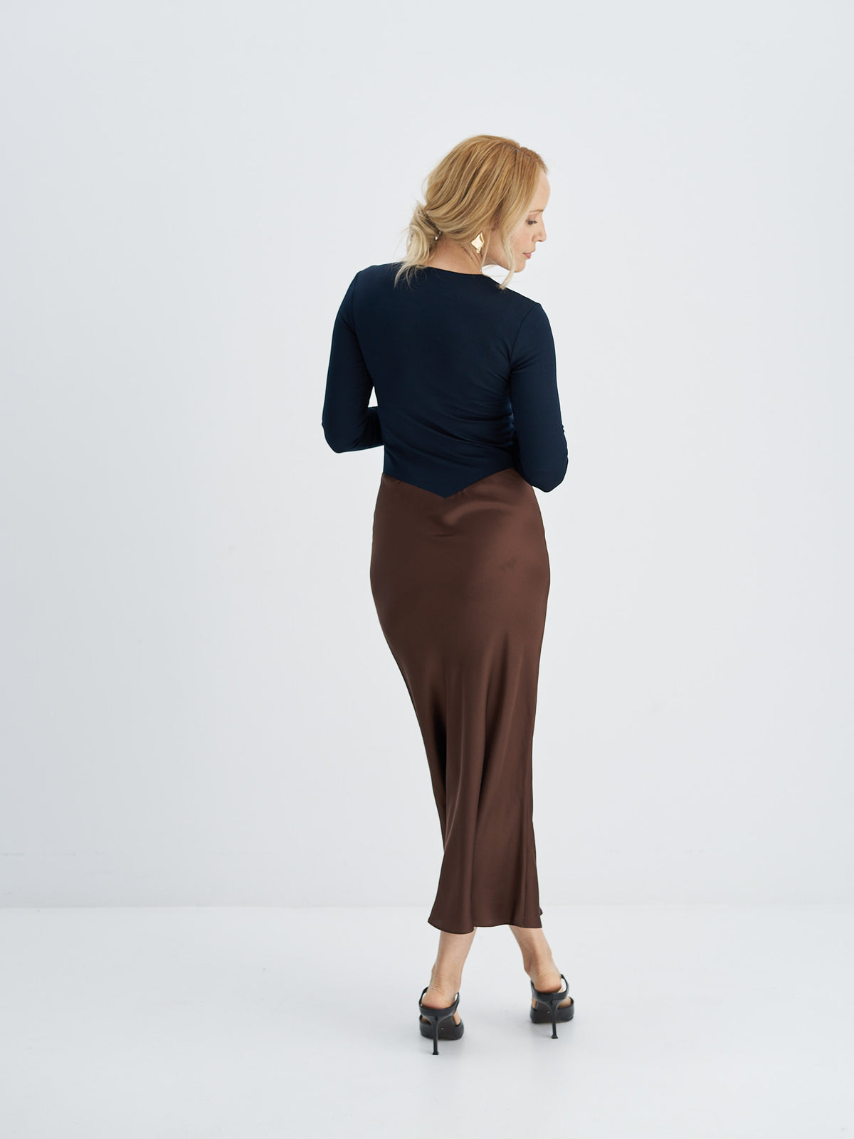 Three-quarter back view of midi dress showing the fitted jersey bodice and chocolate brown silk skirt