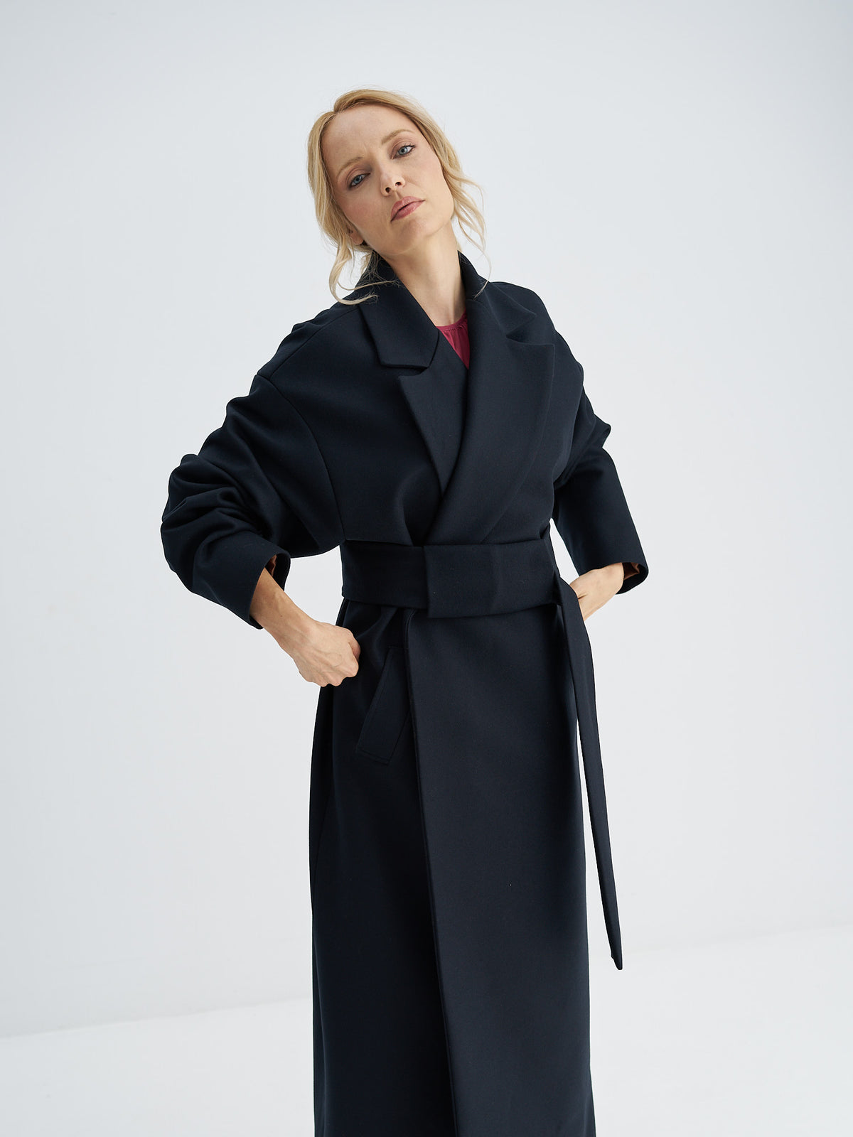 	Belted wool coat showing broad notched lapels and a wide front belt panel
