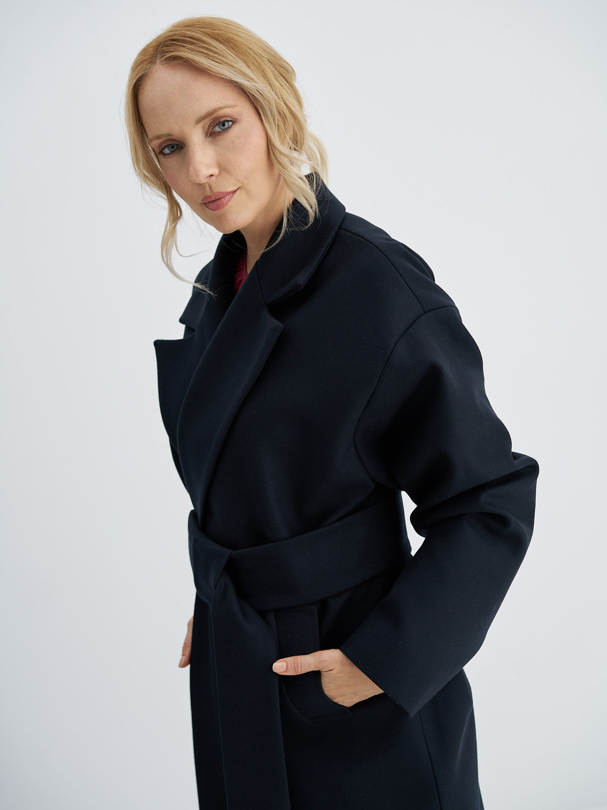Belted wool coat showing broad notched lapels and a wide front belt panel